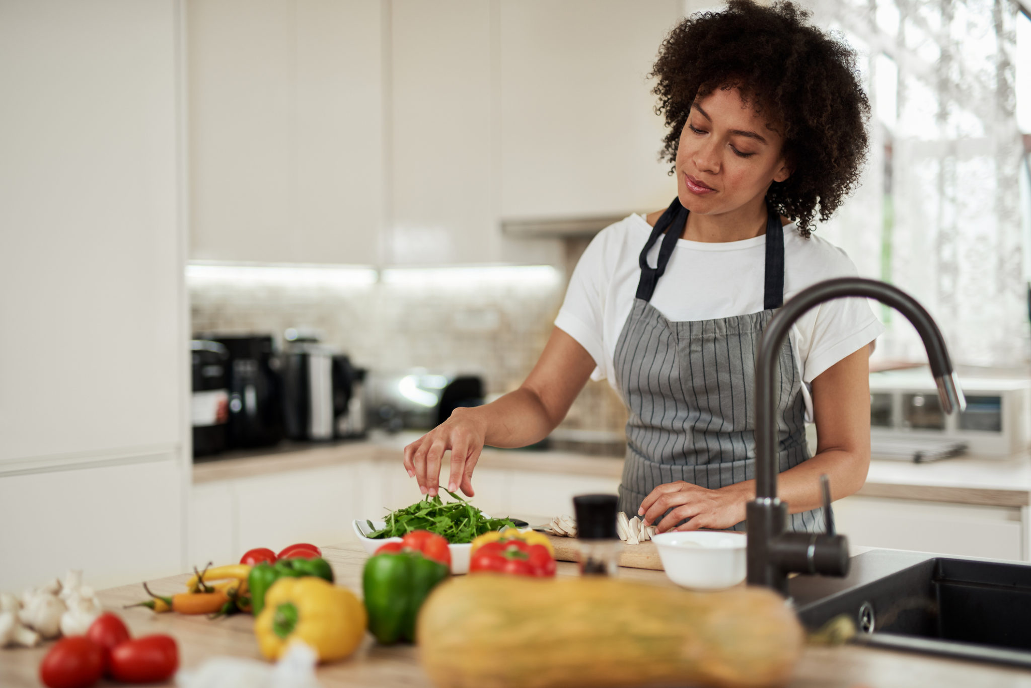 Mixed race woman preparing dinner. - Vegan Action