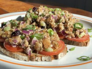 Chikn salad atop toasted bread with tomatoes