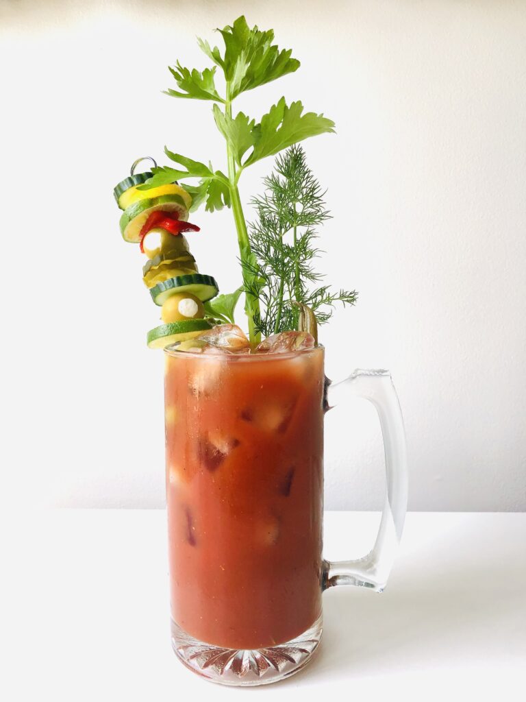 A vegan blood mary with celery and veggies as garnish
